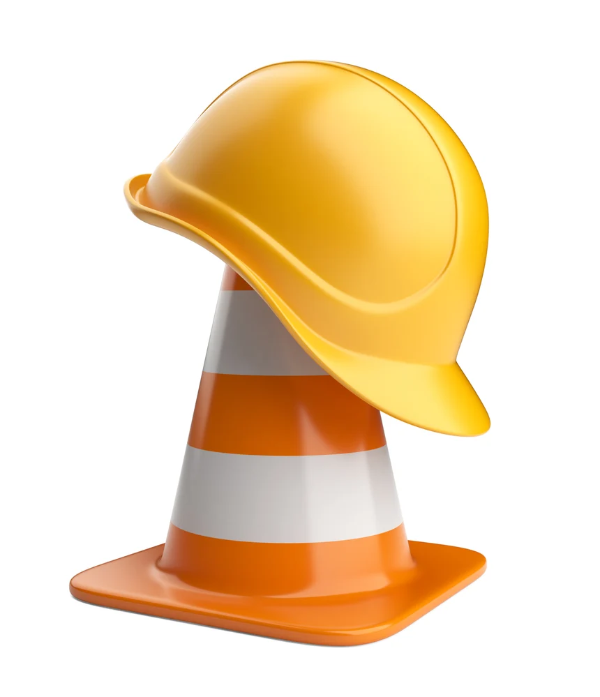 Baustellenkegel mit Bauhelm darüber